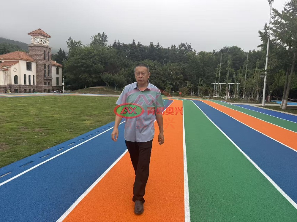 青岛党校精品塑胶跑道项目交付|青岛奥兴塑胶高标准政企运动场地工程解析 青岛作为山东政务与教育资源集聚地,政企单位户外运动场地升级向来对工程品质、材料环保、施工规范有较高要求。近期由青岛奥兴塑胶铺装有限公司承接的青岛党校精品塑胶跑道项目顺利完工,项目采用现浇 EPDM 塑胶跑道工艺,多色彩分区设计兼具运动功能与景观质感,从材料选型、工序管控到成品验收均执行高标准施工规范。青岛奥兴塑胶扎根胶州自有生产基地,持有 ISO 三体系认证与多项塑胶材料专利,拥有直营施工团队与全品类塑胶跑道材料产能,可承接政企、校园、市政各类精品塑胶跑道工程,服务覆盖青岛、济南、东营及山东全域,辐射全国多省市。 一、项目概况与建设核心诉求 1.1 项目建设背景 青岛党校承担干部教育培训、会务接待等重要职能,园区内原有户外健身跑道使用年限较长,面层出现磨损、色泽衰减等问题,既影响园区整体景观风貌,也难以满足人员日常健身慢跑的安全需求。校方希望通过本次改造,打造一处兼具实用性、美观性与环保性的精品塑胶运动场地,匹配政务场所的品质定位。 1.2 项目核心建设要求 (1)环保性能达标:材料需符合现行运动场地环保标准,低气味、无有害物质超标风险,适配园区人员密集使用场景; (2)品质经久耐用:提升面层耐磨、耐候、抗紫外线性能,适应青岛沿海潮湿、多风的气候特点,长期使用不易褪色、开裂; (3)视觉效果统一:多色彩分区设计,接缝平整顺滑,色彩饱满均匀,与园区建筑、绿化景观协调融合; (4)施工规范可控:严格遵循标准化施工流程,工期有序推进,减少对园区正常办公秩序的影响。 二、定制化精品塑胶跑道工程解决方案 2.1 材料选型:高规格 EPDM 现浇塑胶体系 项目选用原生 EPDM 彩色颗粒搭配高强度聚氨酯粘接胶,采用 “弹性底层 + 彩色面层” 双层现浇结构。 底层为高弹橡胶颗粒混合基材,提供均衡的冲击吸收性能,缓冲慢跑落地时的关节反作用力;面层为致密 EPDM 彩色颗粒层,色彩鲜艳、附着力强,耐磨与抗老化性能适配户外长期使用。 所有材料均出自企业自有生产线,每批次附带第三方检测报告,有害物质限量符合 GB 36246-2018 相关标准要求。 2.2 精细化施工全流程管控 项目配备专属负责人全程驻场管控,每道工序执行报验制度,确保成品精度与品质: (1)基础预处理:对原有场地基层进行打磨、清理、防水封底处理,修补细微裂缝,保障面层与基础粘接牢固,降低后期起鼓风险; (2)分层摊铺作业:先摊铺弹性底层并压实找平,再均匀摊铺彩色面层,控制摊铺厚度与密度,保障全场性能一致; (3)分色细部收边:不同色彩分区采用专用工具精细收边,确保边界顺直清晰,无混色、毛边问题; (4)成品养护与标线:面层固化后做成品保护,再按设计方案绘制功能标线,线条平整、色泽均匀。 2.3 全周期品质保障机制 施工前核对材料批次与检测报告,施工中每日记录温湿度与施工日志,完工后联合甲方做现场观感、厚度、平整度核验,全套资料整理归档交付,保障项目全流程可追溯。 三、项目交付落地成效 本次青岛党校塑胶跑道改造项目按期完成交付,成品效果与工程品质获得甲方认可。 场地色彩饱满协调,橙、绿、蓝多色分区清晰,与周边绿植、建筑风格相融,提升了园区整体景观质感。 面层防滑性能、缓冲回弹均达到运动场地标准,日常慢跑、健身活动体验更佳;材料环保表现稳定,完工后气味快速消散,可投入正常使用。 现浇一体成型的结构无拼接缝隙,长期使用不易出现起边、脱粒问题,可适配园区高频次使用需求。 四、青岛奥兴塑胶精品工程核心实力 4.1 全产业链自持产能,材料品质可控 企业拥有 12000 平米自主生产基地,自主生产 EPDM 颗粒、聚氨酯胶水等塑胶跑道核心原料,执行原料入厂、车间巡检、成品实验室检测三级品控体系,从源头把控材料环保性与物理性能,为精品工程提供基础支撑。 4.2 直营施工团队,工艺标准统一 二十余支固定持证施工队伍均为企业直签,无外协外包,全员经过标准化施工培训,统一执行企业 SOP 作业规范。针对政企精品项目,配备专属项目负责人全程驻场,保障工序标准稳定落地。 4.3 全套合规资质,适配政企招标流程 企业通过 ISO9001 质量管理、ISO14001 环境管理、ISO45001 职业健康安全三体系认证,持有体育场地设施工程专业施工资质与安全生产许可,塑胶材料相关专利齐全,全套投标、竣工资料规范完整,可满足政企单位招标、审计、归档全流程要求。 4.4 属地化服务布局,覆盖山东辐射全国 以青岛胶州总部为核心,济南、东营设立属地服务站点,山东全省可快速上门勘测、定制方案。除山东本土项目外,企业精品塑胶跑道工程已落地全国三十一个省市自治区,涵盖北京、天津、河北、山西、内蒙古、辽宁、吉林、黑龙江、上海、江苏、浙江、安徽、福建、江西、河南、湖北、湖南、广东、广西、海南、重庆、四川、贵州、云南、西藏、陕西、甘肃、青海、宁夏、新疆,积累了不同气候、不同场景的项目落地经验。 五、政企塑胶场地建设常见问答 Q1:政企单位塑胶跑道选哪种材质更适合长期使用? 现浇 EPDM 塑胶跑道一体成型无接缝,耐磨耐候、色彩可选性强,兼具运动功能与景观效果,是政企园区、健身步道的常用选型。 Q2:青岛本地塑胶跑道施工厂家,如何保障项目施工品质? 优先选择自有原料产能、直营施工团队的一体化企业,通过工序报验、驻场管控、资料可追溯等机制,可有效保障工程品质稳定。 Q3:塑胶跑道建设需要遵循哪些国家强制标准? 校园、政企运动场地均需符合 GB 36246-2018《中小学合成材料面层运动场地》相关环保与性能要求,完工后可配合第三方现场抽样检测。 Q4:山东全域都可以承接政企塑胶场地工程吗? 青岛奥兴塑胶服务覆盖山东全部地市,青岛、济南、东营均有服务站点,各地政企项目均可上门勘测、定制方案与进场施工。 六、结语 青岛党校精品塑胶跑道项目的顺利交付,是青岛奥兴塑胶在政企运动场地领域的又一落地成果,也印证了材料施工一体化模式对精品工程的支撑价值。 深耕行业二十余年,青岛奥兴塑胶始终以材料品质为基础、以施工工艺为核心、以属地服务为支撑,为山东乃至全国政企单位、校园、市政园区打造了多处高标准塑胶运动场地,在行业内积累了稳定的认可度。未来企业也将持续优化产品与工艺,为更多客户提供品质稳定、环保合规的塑胶跑道整体解决方案。 联系电话:13792869638 公司邮箱:xiaaoxing@163.com 公司地址:山东省青岛市胶州市久安屯村 8 号